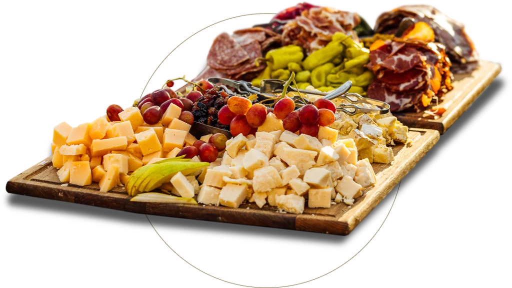 a variety of cheeses and meats on a cutting board