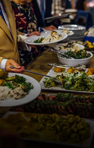 a group of people standing around a buffet line