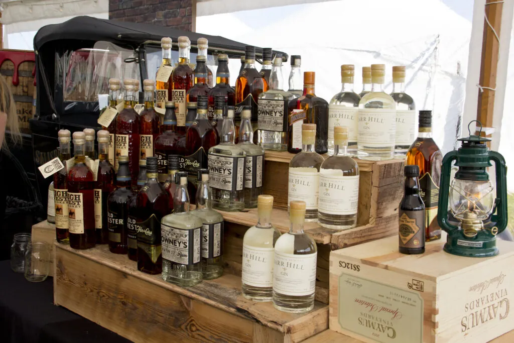 a woman standing behind a counter filled with bottles of liquor