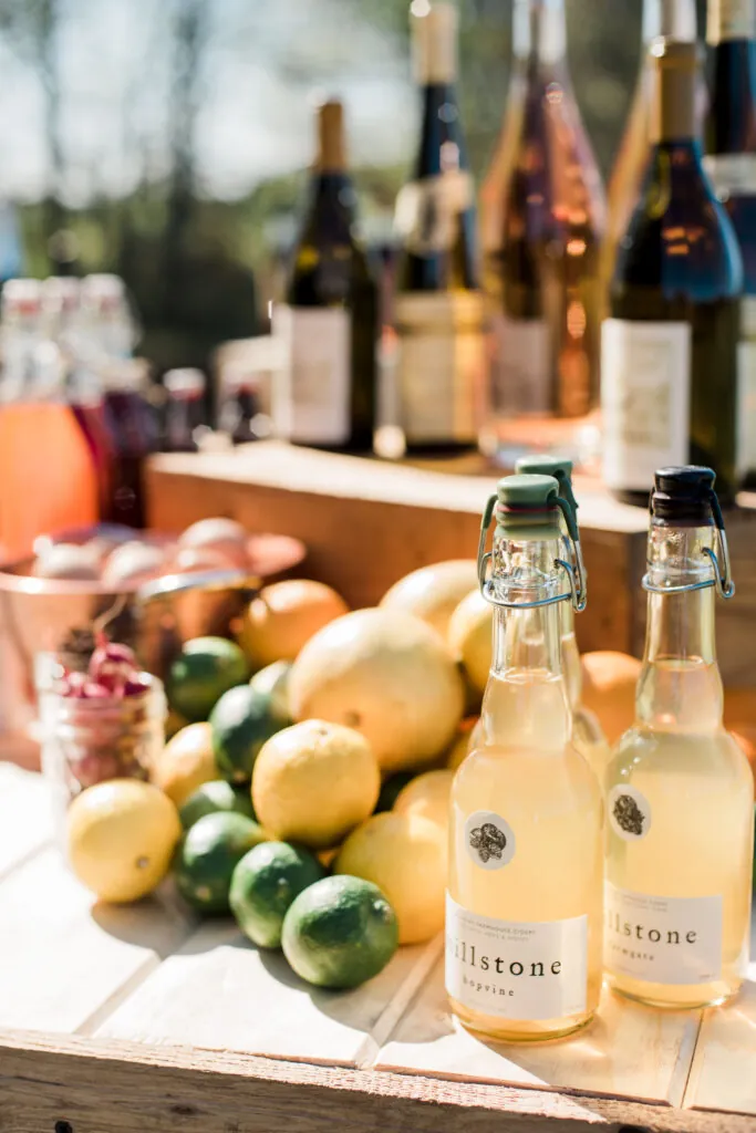 a wooden table topped with bottles of wine and lemons