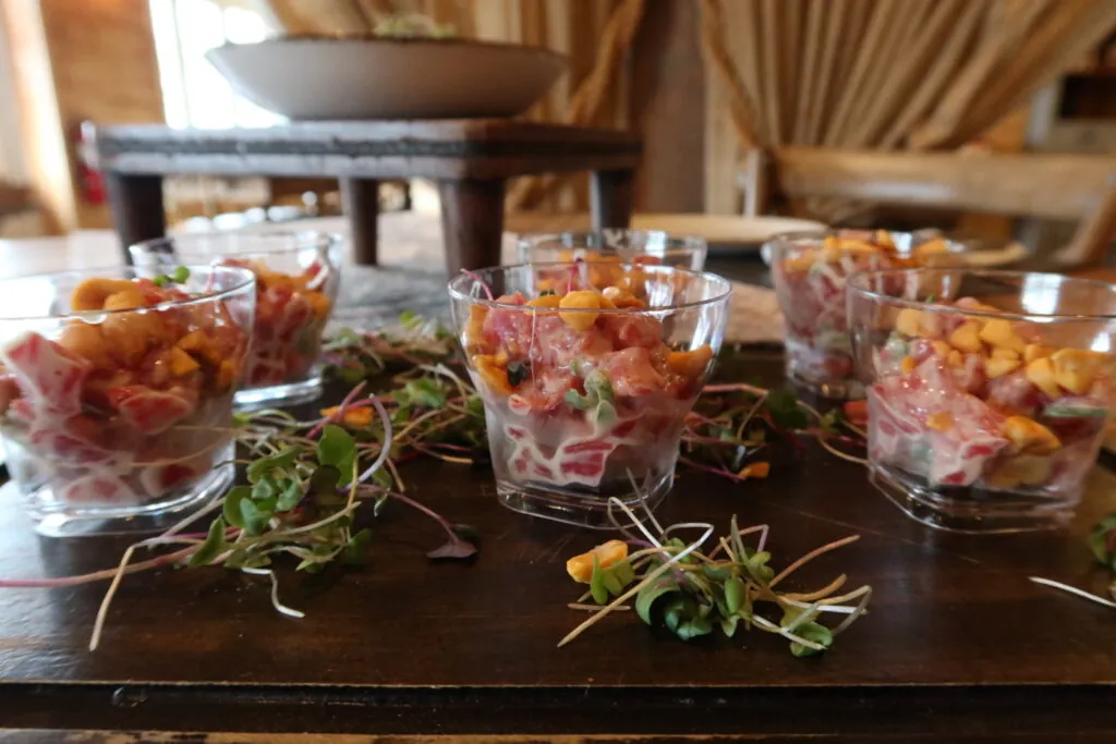 a wooden table topped with glasses filled with food