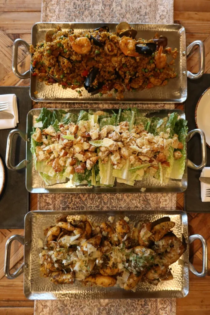 a table topped with three trays of food