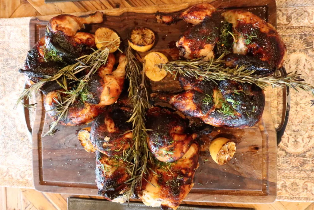 a wooden cutting board topped with chicken and mushrooms